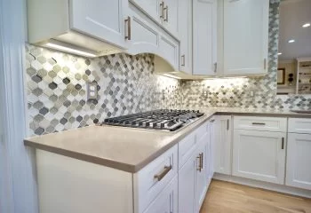 mulit-colored tile backsplash and drop in stove