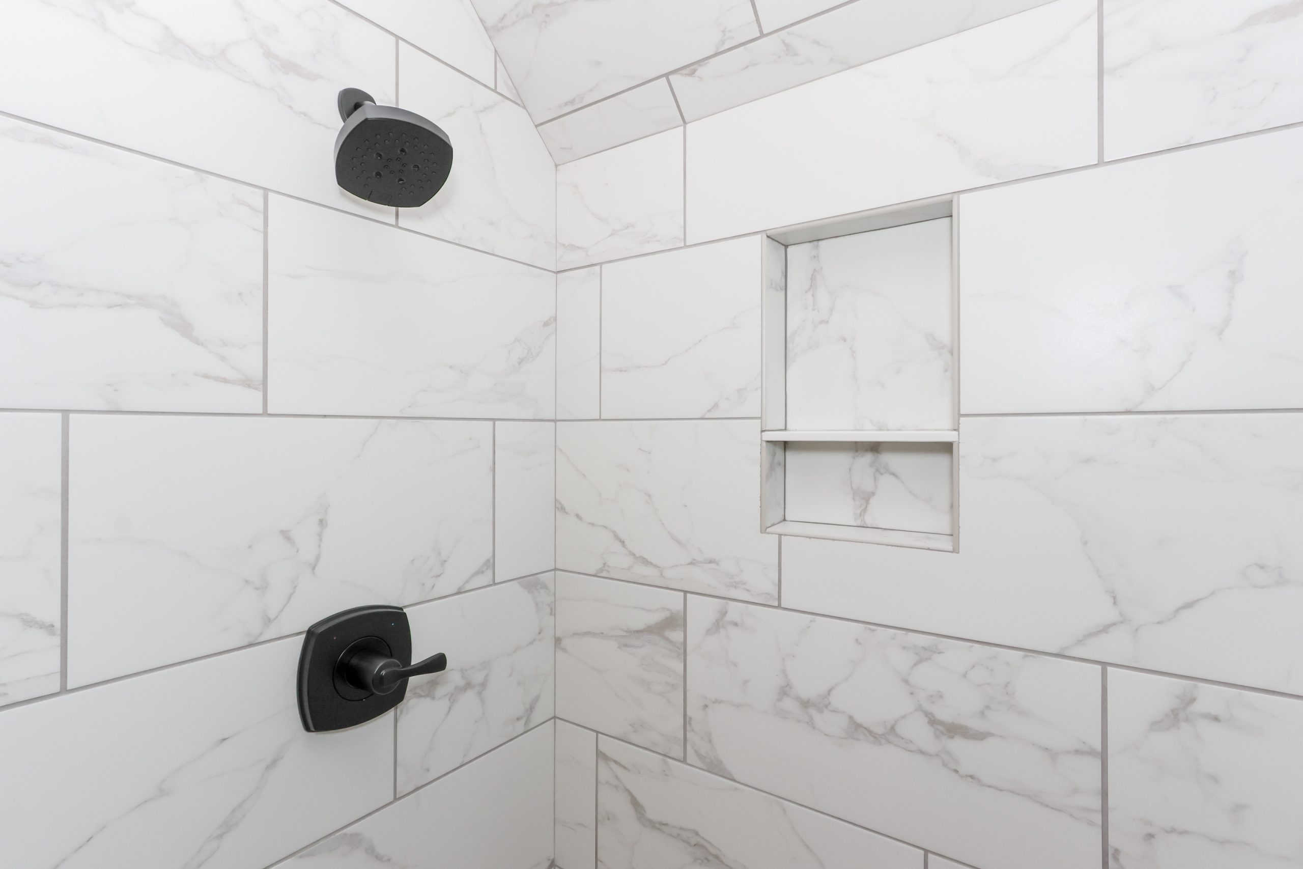Large subway tile with plumbing fixtures in black matte shower
