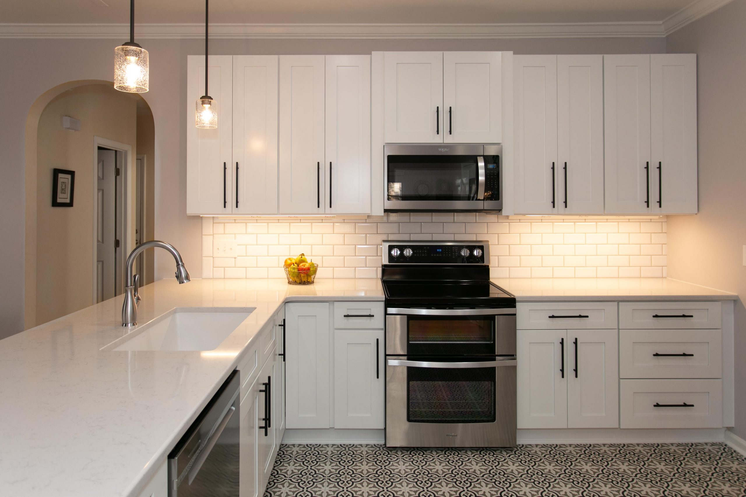 Open kitchen remodel with black and white spanish style designed floor tile