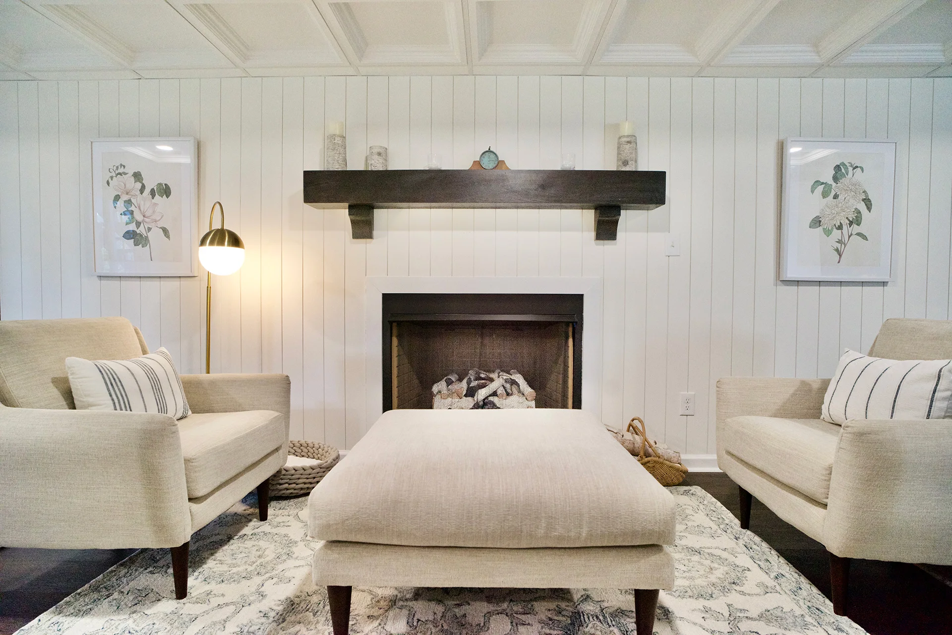 Basement finish with soft white walls, dark wood mantle over the fireplace