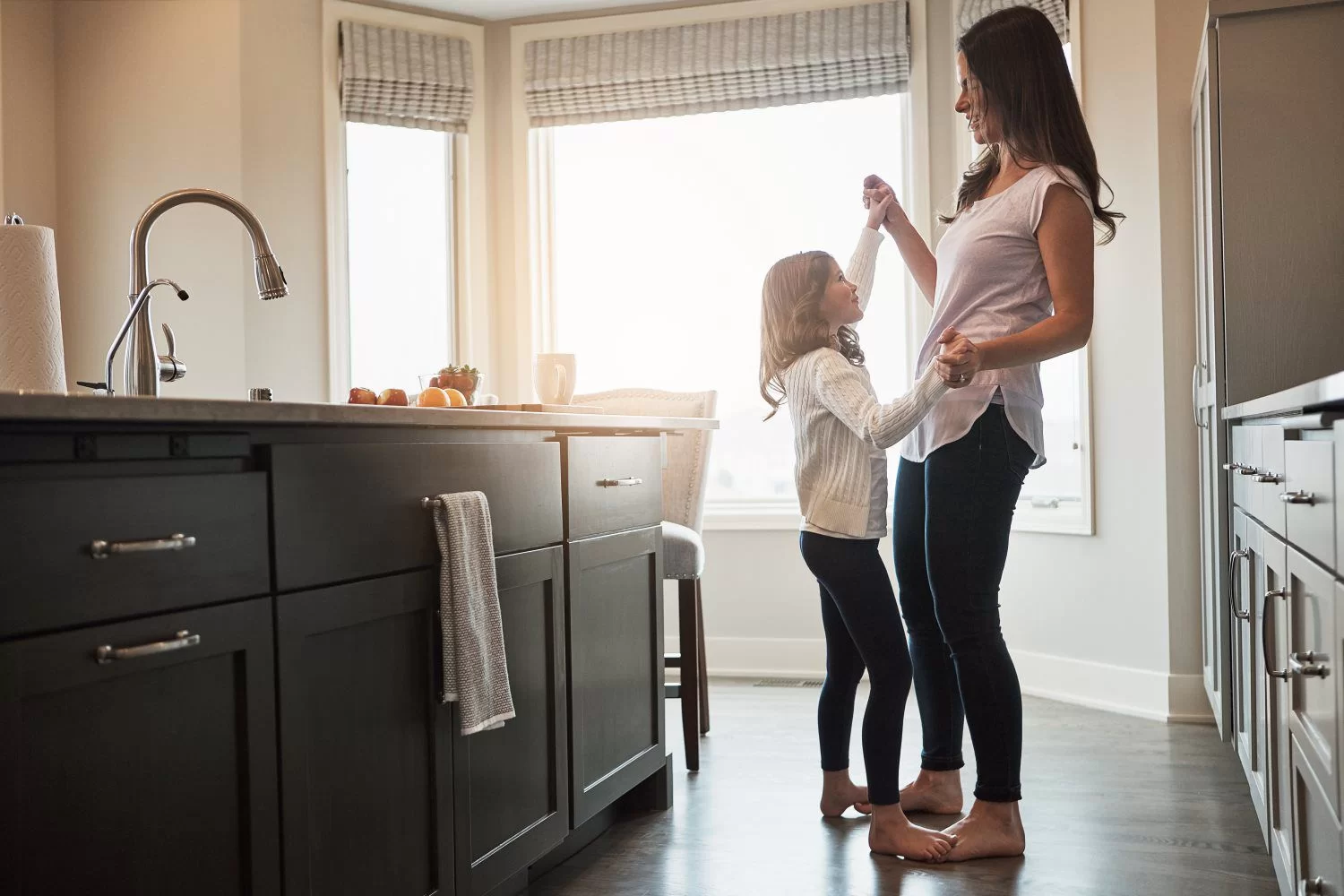 Mother daughter dancing in kitchen