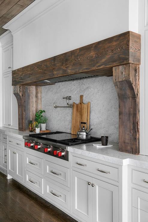 large reclaimed wood trim and corbel accent around rand and built-in range.