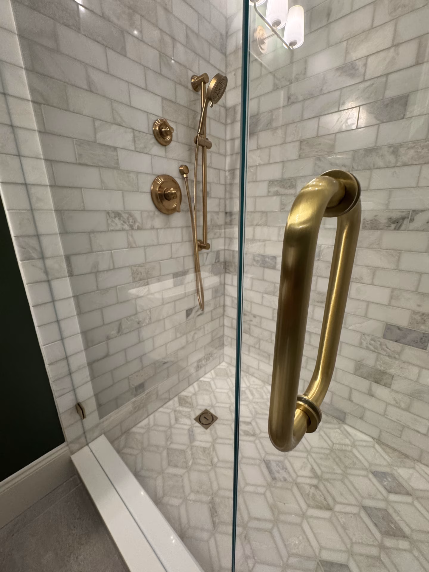 Third-floor walk-in shower with marble tile and brushed gold plumbing fixtures Third-floor walk-in shower with marble tile and brushed gold plumbing fixtures